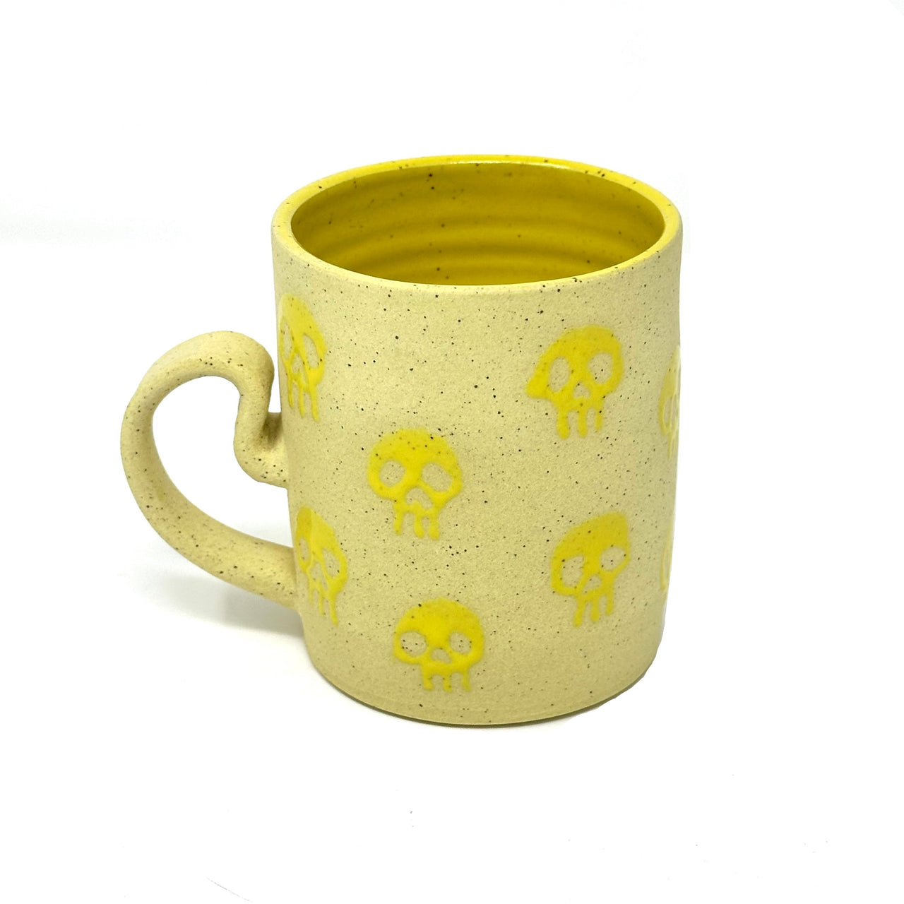 Yellow mug with skull designs on a white background