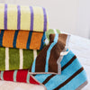 Stack of colorful striped towels on a wooden surface