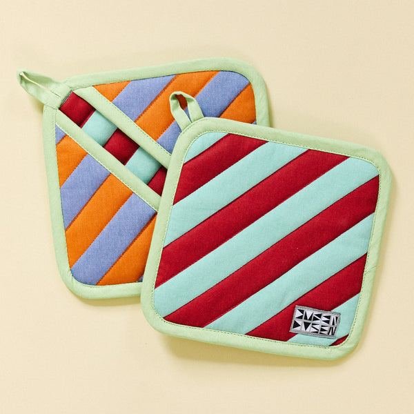 Two colorful striped pot holders on a beige background