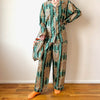 Person wearing a green and gold patterned pajama set on a wooden floor.